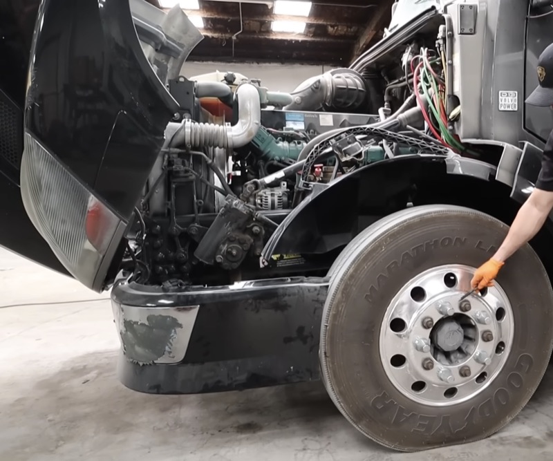 Semi truck with hood tilted open for engine diagnostics and repair